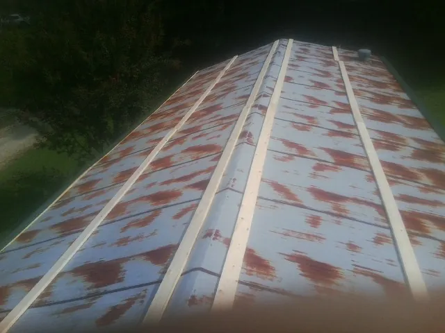 Rusted metal roof panels with new wood purlins before replacement — Storm Damage Roof Repair in Graytown by Roofing Brothers