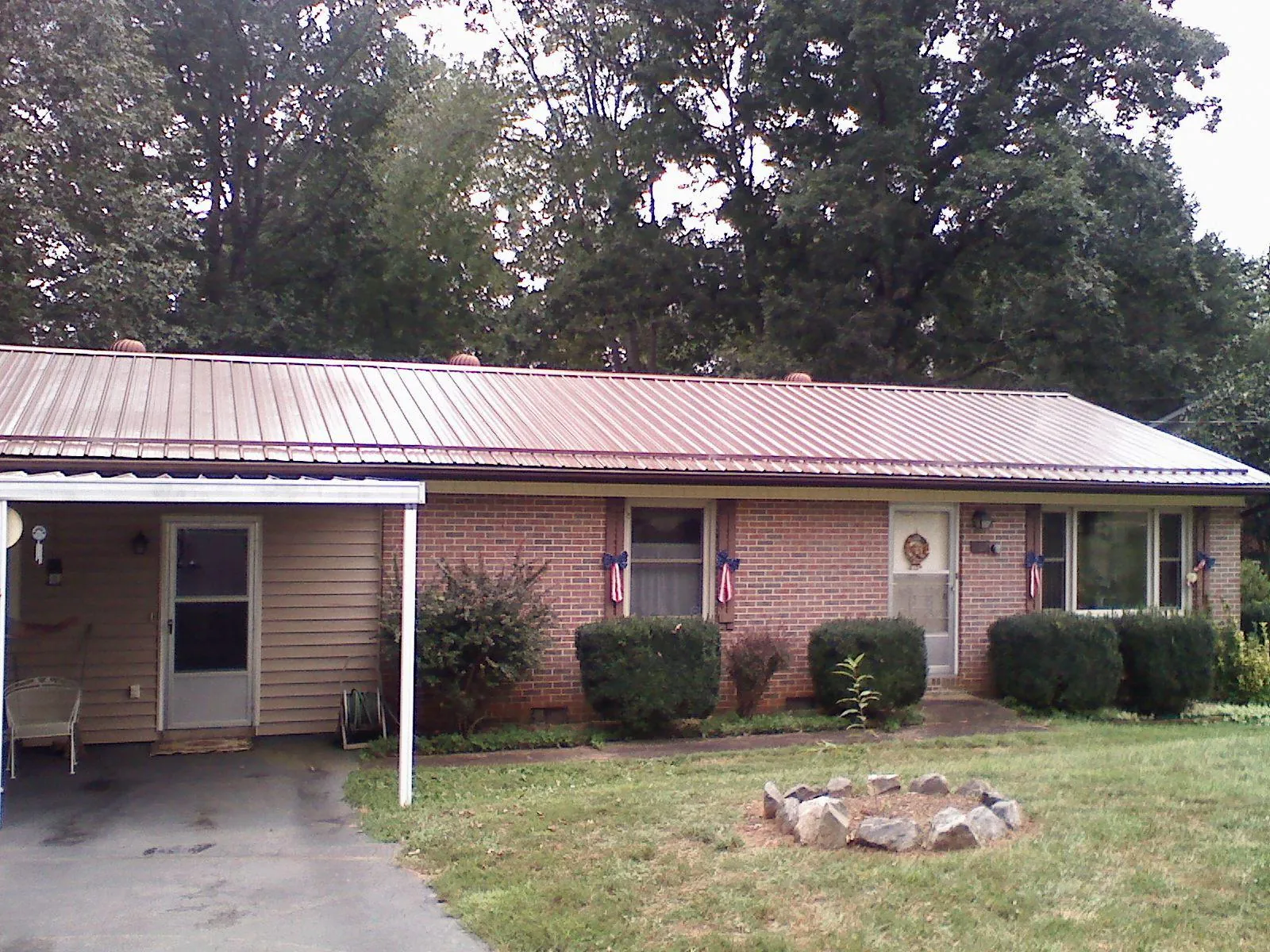 Bronze metal roof and carport on a brick ranch home — Roof Repair work by our crew in Graytown